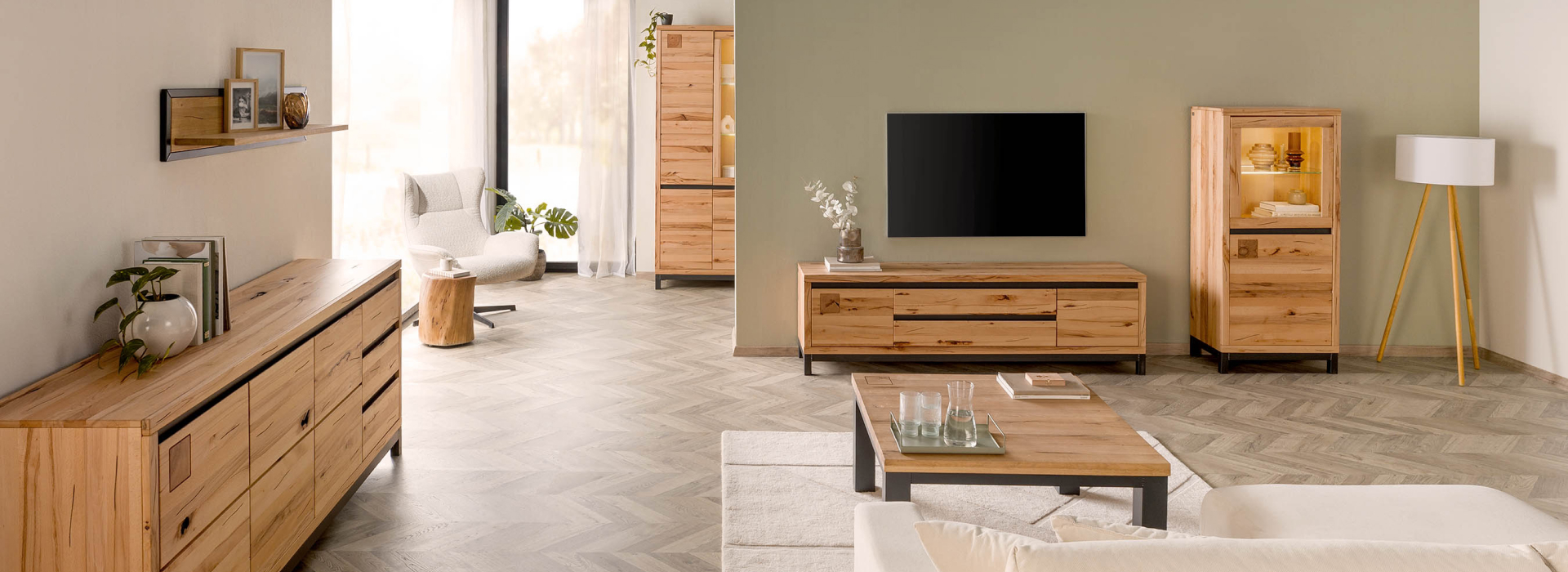 Lichte woonkamer met meubels van kernbeukenhout, een verlichte vitrinekast, een groot dressoir en zwarte designaccenten.