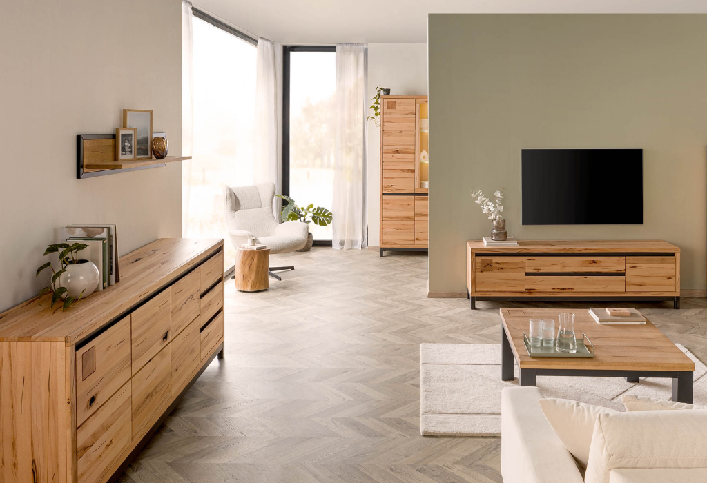 Modern ingerichte woonkamer met meubels van kernbeukenhout, een warm verlichte vitrinekast en stijlvolle metalen details.