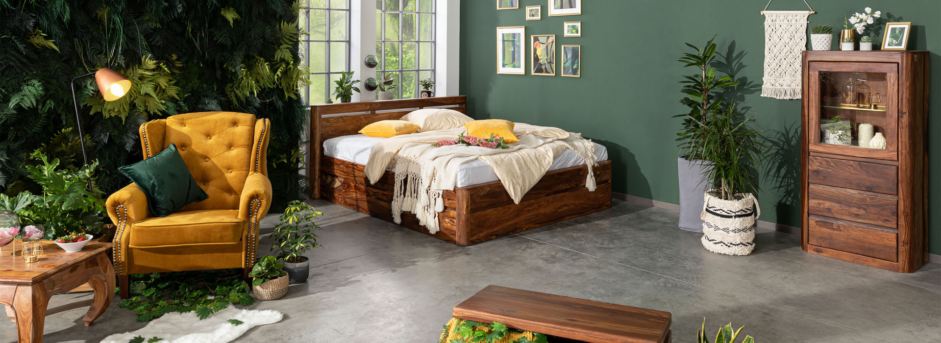 Stijlvolle slaapkamer met een donkerbruin gewaxt bed en een vitrinekast, omringd door planten en warme kleuraccenten.