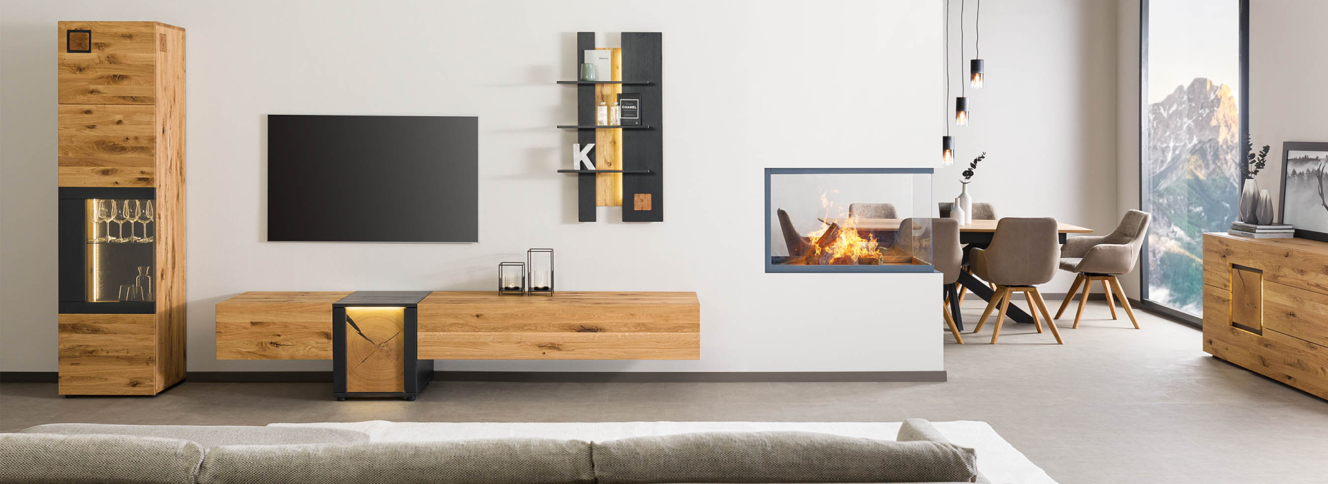 Een lichte woonkamer overdag, met meubels van wild eiken, verlichte vitrines en een moderne open haard in de open woonruimte.