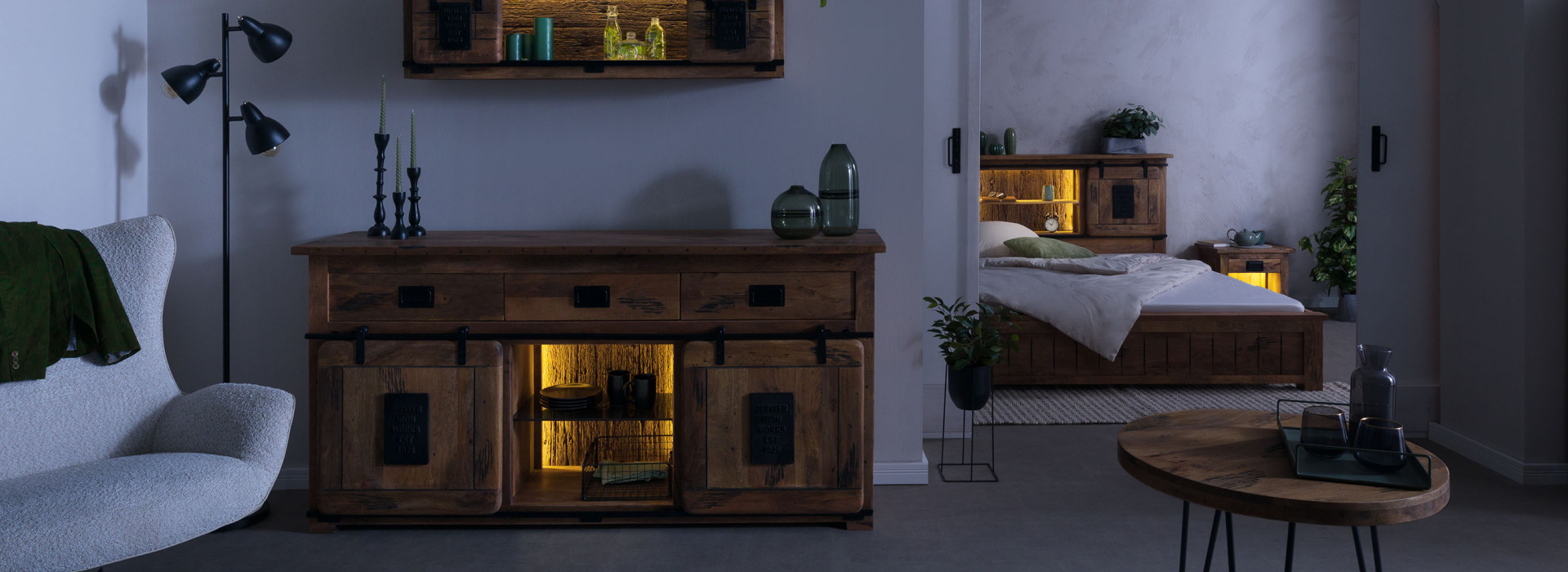 RAILWAY: de woonkamer ’s nachts, met een verlicht dressoir en een wandplank, en een blik op de gezellige slaapkamer.