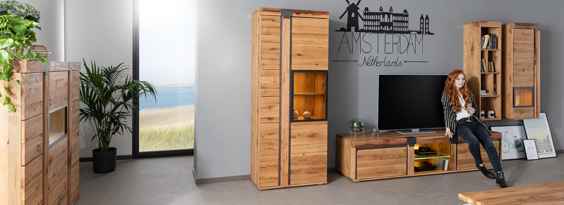 Moderne woonkamer uit de serie NEW AMSTERDAM met tv-meubel, highboard, vitrinekasten, wandkast en salontafel in natuurlijke houtlook