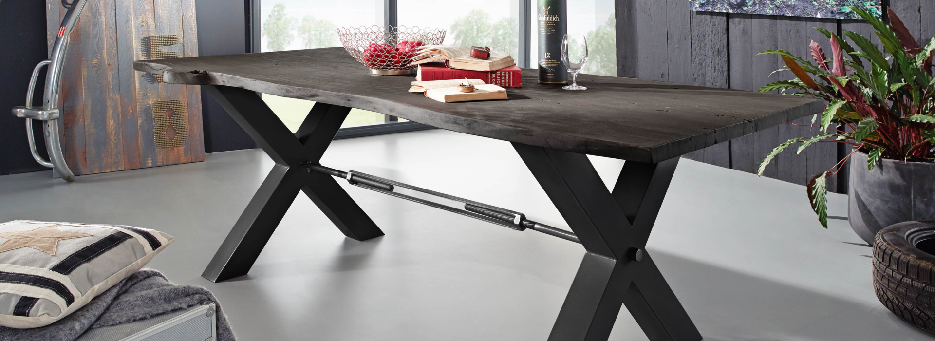 Massieve boomtafel met een donker houten blad, opvallende boomrand en een zwart metalen X-onderstel.