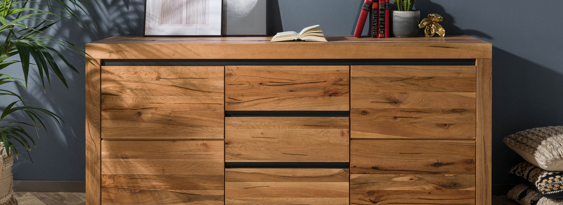 Massief dressoir van wild eiken met levendige nerf, zwarte greepstrips en ruime lades en deuren.